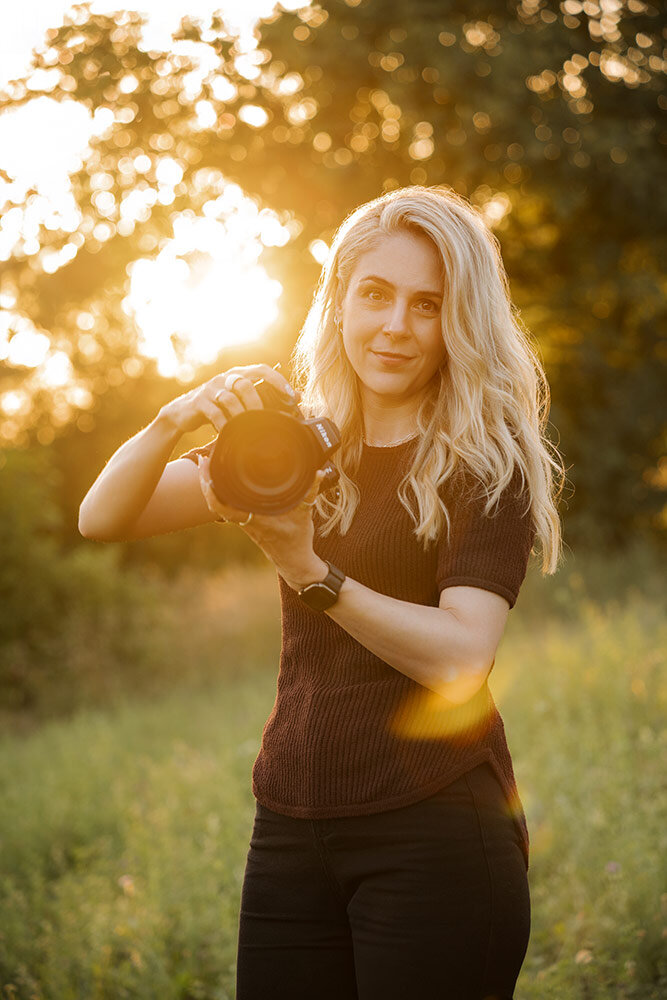 Stephanie Hafner, Pferdefotografin, hält im warmen Gegenlicht ihre Kamera in den Händen